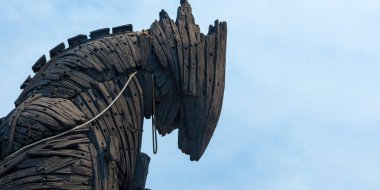 Bir atı andıran büyük ahşap heykel açık mavi gökyüzünün altındaki kıyı bölgesinde belirgin bir şekilde duruyor..