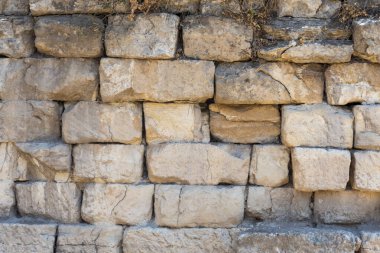 Bu kompozisyon, taşların işçiliğini ve doğal renklerini vurgulayan sağlam bir taş duvar sergiliyor..