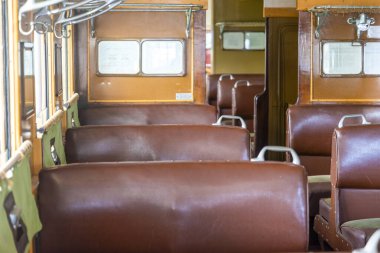 Eski bir trenin içi kahverengi deri koltuklar ve ahşap paneller içerir. Doğal ışık pencerelerden girer, boşluğu aydınlatır. Bölge sessiz ve nostaljik bir atmosferi yansıtıyor..