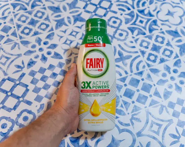 Mavi Desenli Arkaplanda Bir Şişe Peri Platin Jel Deterjanı Tutmak