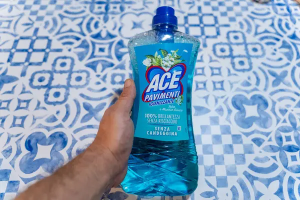 Mavi ve Beyaz desenli bir yüzey üzerinde bir şişe ACE Pavimenti yer temizleyicisi