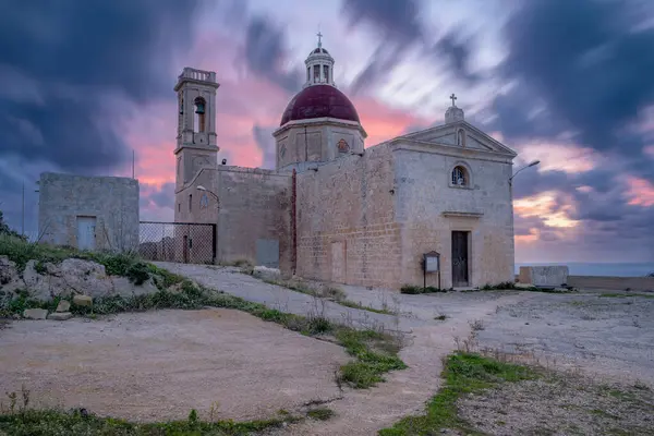 Kubbe ve çan kulesinin dramatik alacakaranlık altında olduğu tarihi kilise.