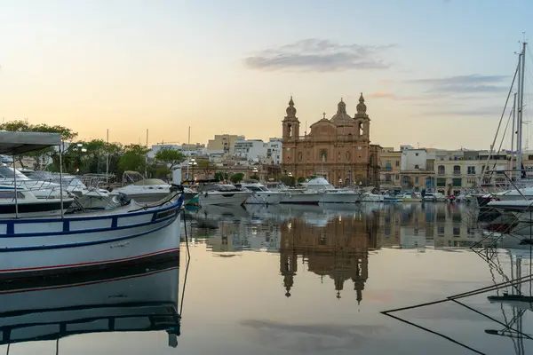 Arka planda Msida Kilisesi ile Msida Creek Marina 'da Akşam Yansımaları