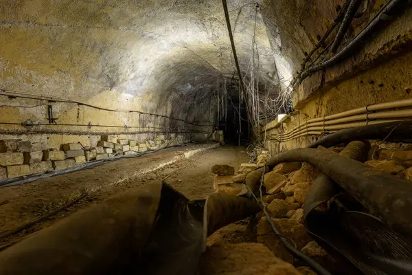 Korunmasız kablolar, enkaz ve kayalık zemini olan terk edilmiş bir yeraltı tüneli.
