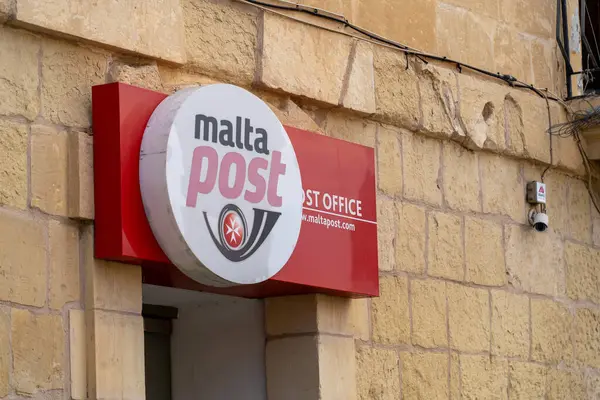 Malta - 20 Ekim 2024: MaltaPost, Malta 'da geleneksel bir taş duvarın önünde