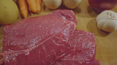 Tahtada taze havuç, mantar, patates, soğan ve sarımsaklı çiğ biftek.