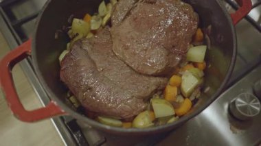  Fırında kızartılmış sığır rostosu doğranmış sebzelerin üzerine konur.