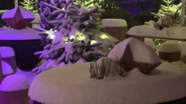Geceleri dışarıda kar yağarken ışıkları olan sihirli karlı Noel ağacı, bayram etkinliği konsepti