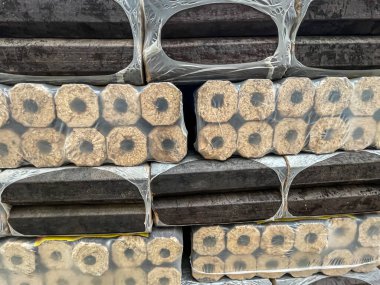 Ahşap kömür, plastiğe sarılı yığın, alternatif ısıtma, yenilenebilir enerji, depoda yakacak odun, satış vitrini, tam çerçeve.