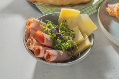 Sabah kahvaltısı. jambon, peynir ve lahanalar kasede, karamsar sabah sahnesi, güneş ışınları ve yüksek açılı gölge manzarası