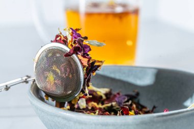 Renkli kurutulmuş çiçek yaprakları çay maşası ve mavi kase, çay konsepti, yakın çekim, makro