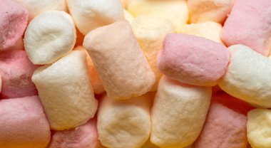 Dikey yığında renkli marşmelov parçaları, pastel renklerde afiş arkaplanı, tam çerçeve