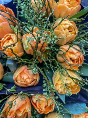 turuncu renkli lale buketleri yeşil dolgulu siyah kağıtlı ambalajlar satışa hazır, dikey çekim, yukarıdan aşağı manzara, boş çerçeve