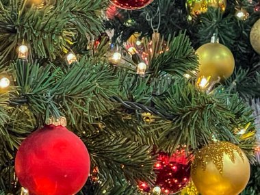Altın ve kırmızı toplarla Noel ağacı süslemesi, ışıklı ışıklar ve çelenkler, Noel kartı, selamlar, tam çerçeve, kapat