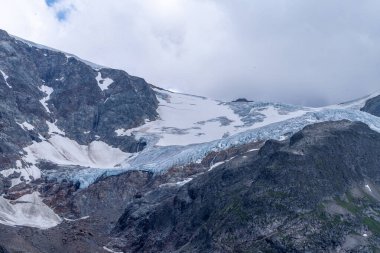 Yazın kara kayanın üzerindeki buzul manzarası bulutlu bir günde, Steingletscher, İsviçre
