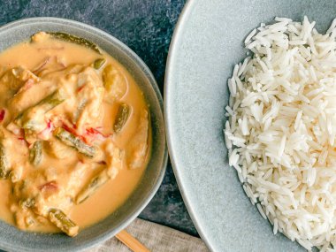 Kırmızı Tayland usulü körili tavuk. Tabakta sos. pirinç ayrı tabakta pastel mavi tabakta, yemek çubukları peçete yüksek açılı, kapat.