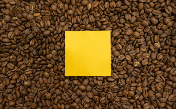 overhead image of coffee beans with yellow post it to put your logo or message
