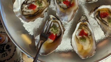 İstiridye ve tuzlu ve çatallı diğer malzemelerin yakın plan çekimi.