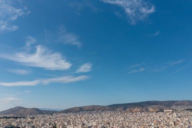 Yunanistan 'ın Pire kentinin nefes kesici hava manzarası batıya doğru bakıyor ve Egaleo Dağı' na doğru uzanan uçsuz bucaksız şehir manzarasını gösteriyor. Kalabalık konut binaları genişliyor.