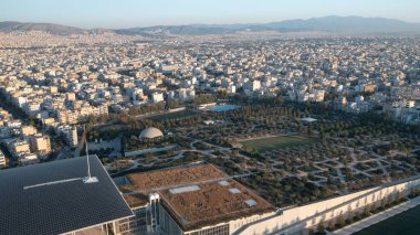 An aerial perspective of the Stavros Niarchos Foundation Cultural Center in Athens, Greece, highlighting the solar panel-covered roof and the structured landscape of the surrounding park. The design clipart