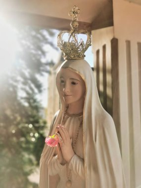 Meryem Ana 'nın heykeli elleri bağlı, bir taçla dua ediyor. Fatima Leydimiz. Paray-le-Monial, Fransa.