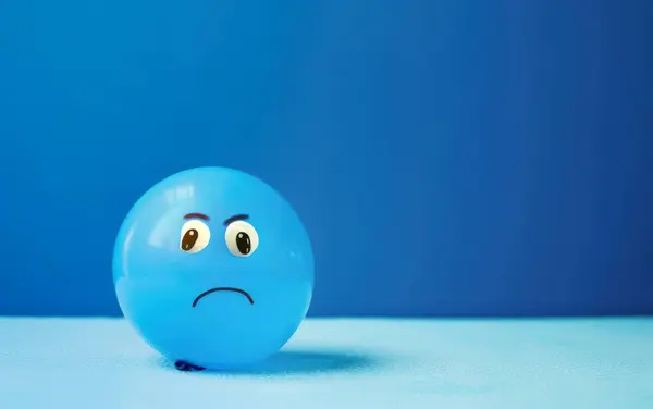 Blauwe Ballon Een Blauwe Achtergrond Met Een Treurig Getekend Gezicht — Stockfoto