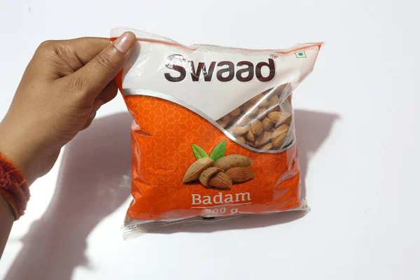 stock image hand holding plastic package of Swaad Badam almond nuts