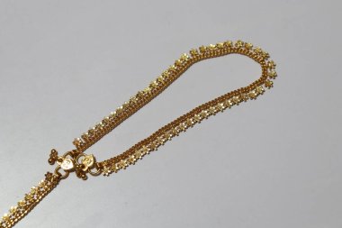 Yapay el, beyaz arka planda izole edilmiş taştan zincir boncuklar.