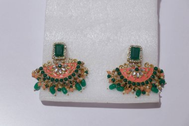 Yapay el, beyaz arka planda izole edilmiş taştan zincir boncuklar.