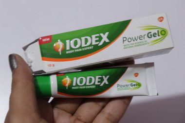 Iodex vücut ağrısı jeli ve orjinal kutuyla kadın avucunda