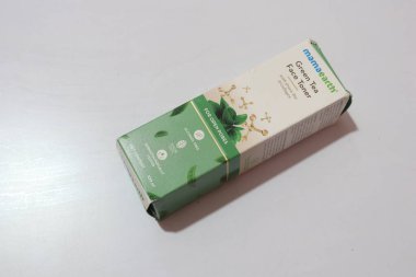 Mama Earth Green Tea Face Toner ve yeşil çay beyaz arka planda, Hyderabad Hindistan 'da izole edildi.