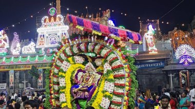 Hindistan 'ın Tamil Nadu şehrinde Thiruvannamalai' de Arunachalesvara Swamy Tapınağı Karthika Deepam Festivali 'nde çiçeklerle süslenmiş kutsal Hindu tanrısı putuna tapan insanların gece görüşü.