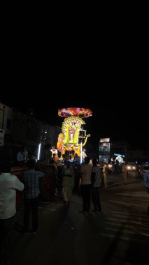 Hindistan 'ın Tamil Nadu şehrinde Thiruvannamalai' de Arunachalesvara Swamy Tapınağı Karthika Deepam Festivali 'nde çiçeklerle süslenmiş kutsal Hindu tanrısı putuna tapan insanların gece görüşü.