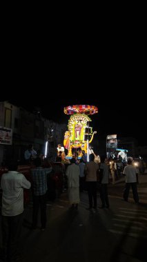 Hindistan 'ın Tamil Nadu şehrinde Thiruvannamalai' de Arunachalesvara Swamy Tapınağı Karthika Deepam Festivali 'nde çiçeklerle süslenmiş kutsal Hindu tanrısı putuna tapan insanların gece görüşü.