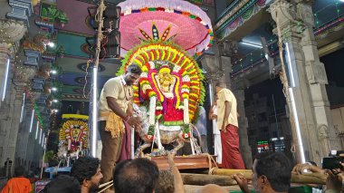 Hindistan 'ın Tamil Nadu şehrinde, Thiruvannamalai' de, Arunachalesvara Swamy Tapınağı Karthika Deepam Festivali 'nde çiçeklerle süslenmiş kutsal Hindu tanrısı putuna hizmet eden insanlar.