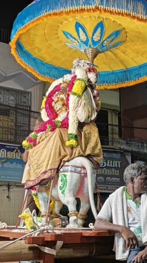 TAMIL NADU, INDIA - NOVEMBER 26, 2023: İnsanlar Hindistan 'ın Tamil Nadu kentinde düzenlenen Thiruvannamalai' de Arunachalesvara Swamy Tapınağı Karthika Deepam Festivali 'nde çiçek desenli kutsal Hindu tanrısı putuna tapıyorlar.