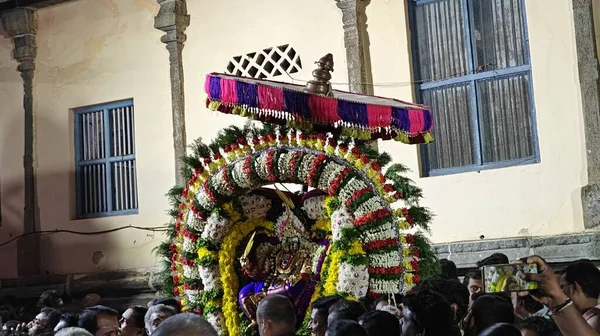 Hindistan 'ın Tamil Nadu şehrinde, Thiruvannamalai' de, Arunachalesvara Swamy Tapınağı Karthika Deepam Festivali 'nde çiçeklerle süslenmiş kutsal Hindu tanrısı putuna hizmet eden insanlar.