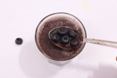 Beyaz arka planda izole edilmiş sağlıklı yaban mersini suyu