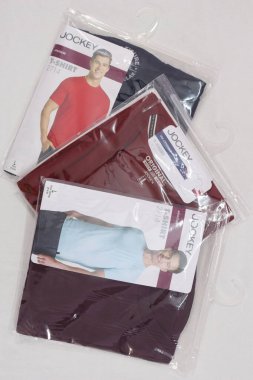 Beyaz arka planda tıklım tıklım erkek tişörtleri