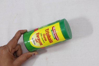 Elinde yeşil bir Hint ilacı paketi var.