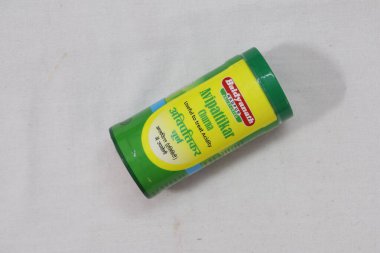 Elinde yeşil bir Hint ilacı paketi var.