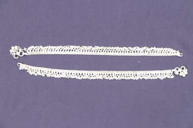 Gri arka planda gümüş mücevher bilezikler 