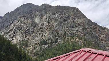 Kayalık dağlar ve kırmızı çatı manzarası