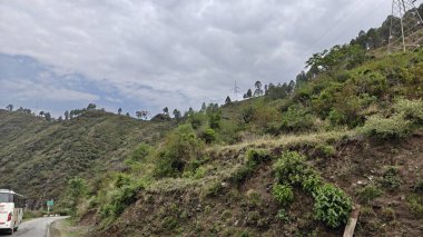 Himalaya dağlarının yeşil yamaçları ve bulutlu gökyüzü