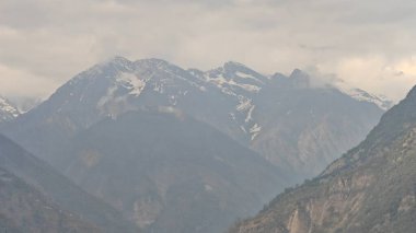 Himalaya dağları ve gökyüzünde bulutlarla dolu güzel bir manzara.