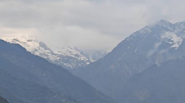 Himalaya dağları ve gökyüzünde bulutlarla dolu güzel bir manzara.