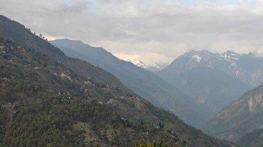Himalaya dağları ve gökyüzünde bulutlarla dolu güzel bir manzara.