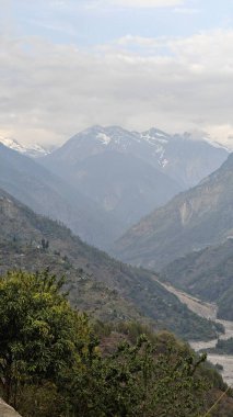 Himalaya dağları ve gökyüzünde bulutlarla dolu güzel bir manzara.