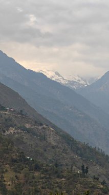Himalaya dağları ve gökyüzünde bulutlarla dolu güzel bir manzara.