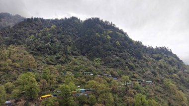 Dükkanları olan sisli dağların güzel manzarası, Kedarnath Tapınağı Yolu 'ndaki Shiva fanatikleri için oteller.